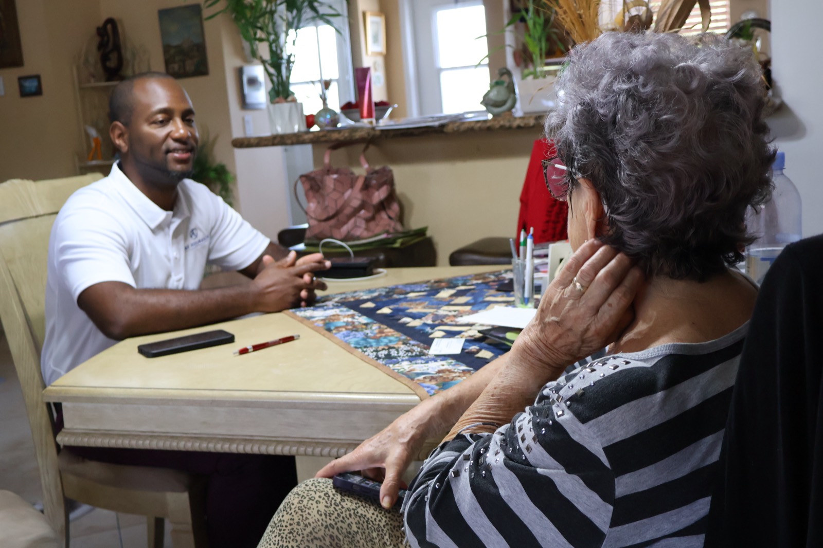 A&E Insurance Agency advisor meeting with a South Florida Medicare client at her kitchen table to review plan options